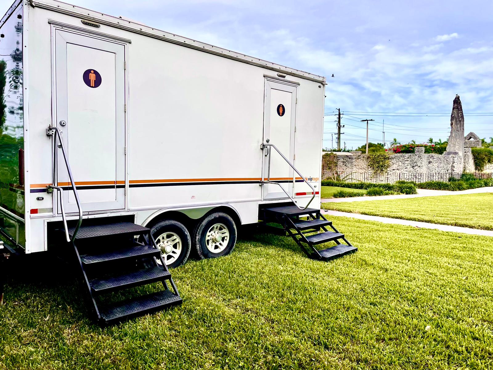 A restroom trailer parked on the grass